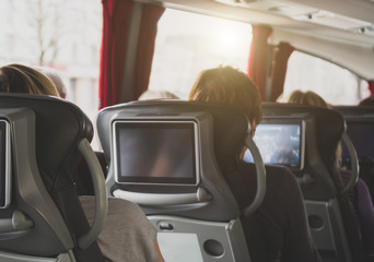 Tourist bus with passengers and built-in LCD tablets.