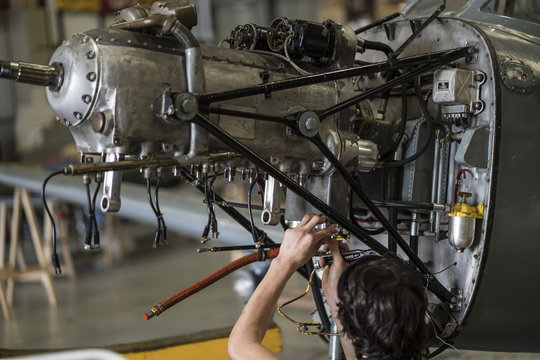 Fototapeta Crop hands repairing plane engine