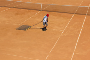 Fototapeta na wymiar Cleaning of the tennis court. Court service. Cleaning of the ground for tennis.