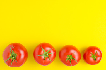 Tomatoes on a bright yellow background.