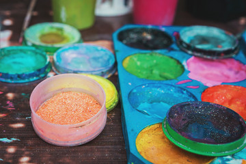  pallets for aqua make-up. Colorful paint tubes and brushes used for face art painting. Tools background and texture