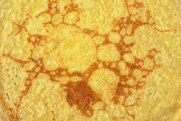 Texture of a cooked thin pancake, closeup.