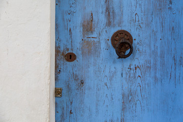 An old faded blue door. Door handle and lock.
