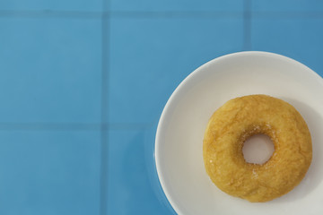 Donut on white plate floating in swimming pool