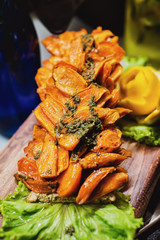 Bulgarian pepper make in grill is cut with long bits and is well laid out on a wooden board.