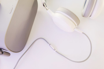 Stylish headphones and VR headset on a white table top view. 