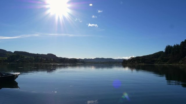 Fly fisherman on boat arrives at his fishing spot on lake Whakamaru in New Zealand