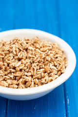 puffed spelt in white bowl on wooden background
