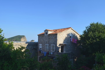 Fototapeta premium Laundry hanging out to dry on a stone house surrounded by trees