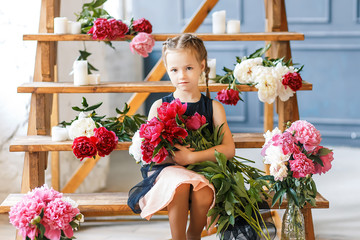 Cute little girl with peonies in studio