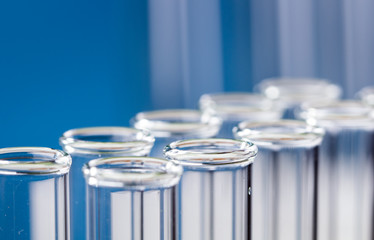 Glass test tubes on blue background in laboratory.