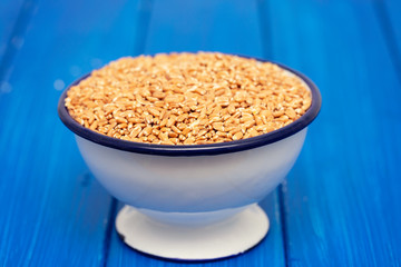 uncooked spelt in white bowl