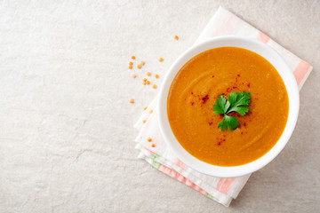 Red lentil cream soup on gray stone background