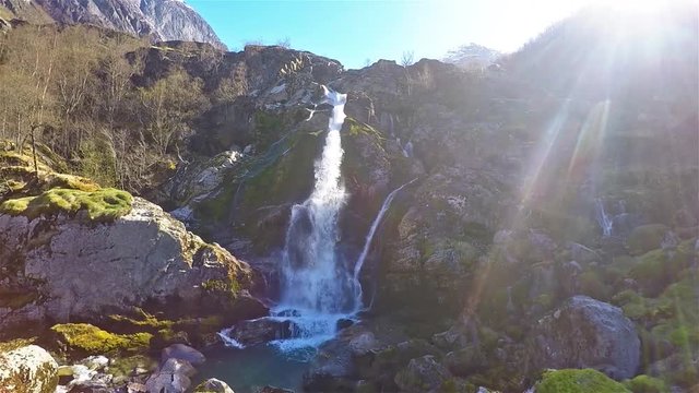 Front view of little waterfall surrounded by rocks at Briksdal glacier in Norway