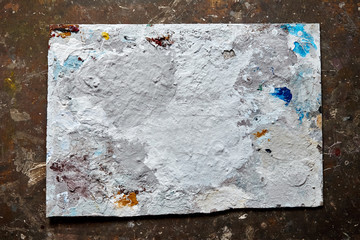 Dirty dried artist palette with paint blots and stains