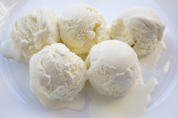 Set of ice cream scoops on a white plate, closeup.