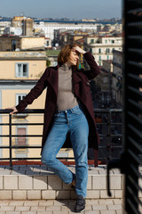 portrait of an attractive woman from the balkony in street background Naples, Italy