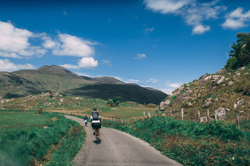 Obraz premium People riding bicycles on the scenic roads of Black Valley in county Kerry, Ireland