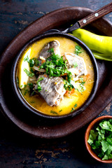 CHILEAN FOOD. Fish soup CALDILLO DE CONGRIO served in clay bowl, top view