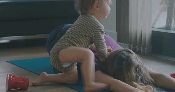 Little toddler interrupting mother doing yoga