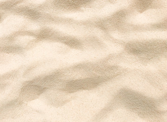 Fototapeta na wymiar Beach sand texture. Beautiful sandy background with golden and white grains. Wavy and dry sand