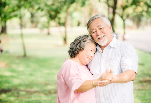 senior Asian couple dancing in the park