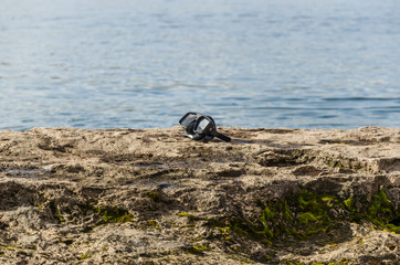 goggles on a rock by the lake