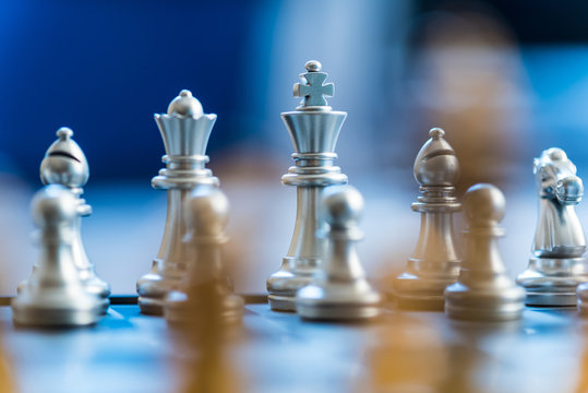 silver chess pieces on a silver chessboard, business strategy concept