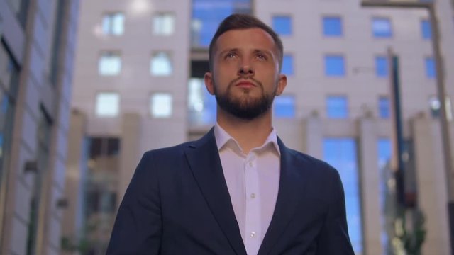 handsome white collar worker walking in city downtown background. successful businessman wearing elegant blue jacket and white shirt going down the street