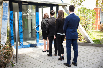 Businesspeople Standing At The Entrance Of Job Center