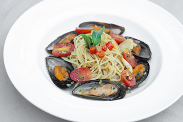 Pasta spaghetti with mussel and tomatoes isolated on white plate