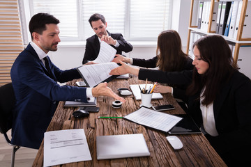 Businesspeople Discussing Paperwork In Office