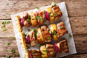 Grilled pork kebabs with fresh apples and red onions on skewers close-up. horizontal top view