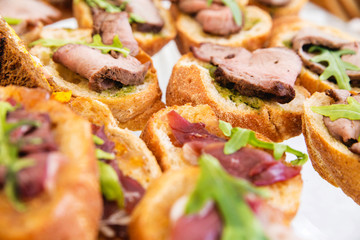 sandwiches with meat and pesto sauce on a banquet table