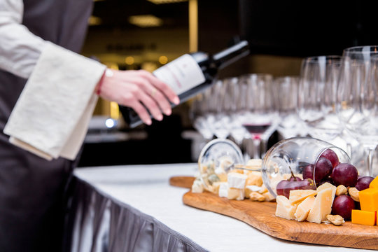 the waiter serves the wine and cheese tasting area