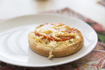 bun with cheese and tomato on a plate