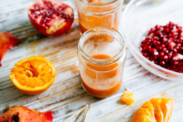 Pomegranate and orange juice is poured on a jar glas. Fruts pomegranate seeds and orange cut n half...