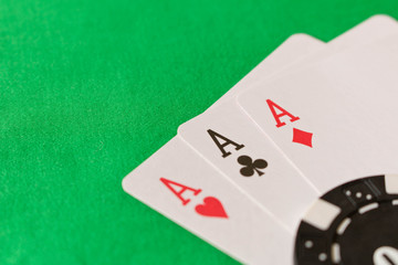 Playing cards, poker chips on the green table . The concept of winning . Close up