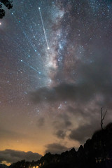 Colorful Milky Way and yellow light at mountains. in Thailand