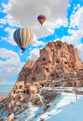 Foto op Plexiglas Lichtblauw Heteluchtballon die over rotslandschap vliegt in Cappadocië, Turkije