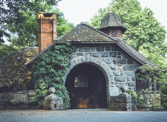 Naklejka premium Old stone pumphouse in tudor revival architecture at Ringwood State Park, NJ in vintage setting