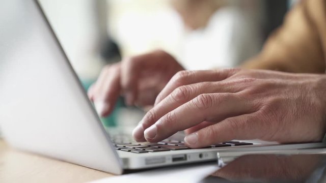 Closeup of man typing on laptop keyboard