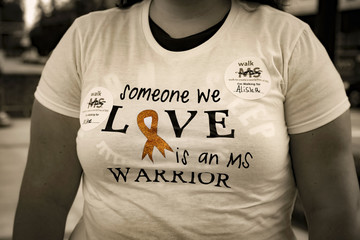 Partial view of woman wearing supportive Multiple Sclerosis/MS message on t-shirt - retro black and...