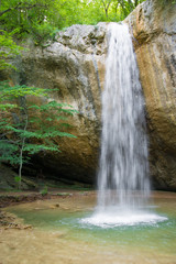Obraz premium Mountain waterfall vertical in the spring forest