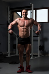 Handsome Muscular Man Flexing Muscles In Gym