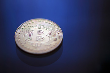 Bitcoin coin on blue light background