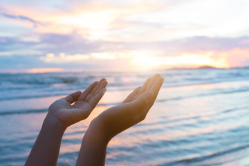 Closeup woman hands praying for blessing from god during  sunset background. Hope concept.