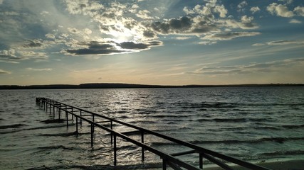 Summer landscape: sunset with clouds over the lake