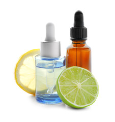 Bottles of citrus essential oil, lemon and lime on white background