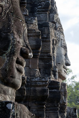 Siem Reap Cambodia,  faces carved into stone at the Bayon Wat in late afternoon sunlight, a 12th...